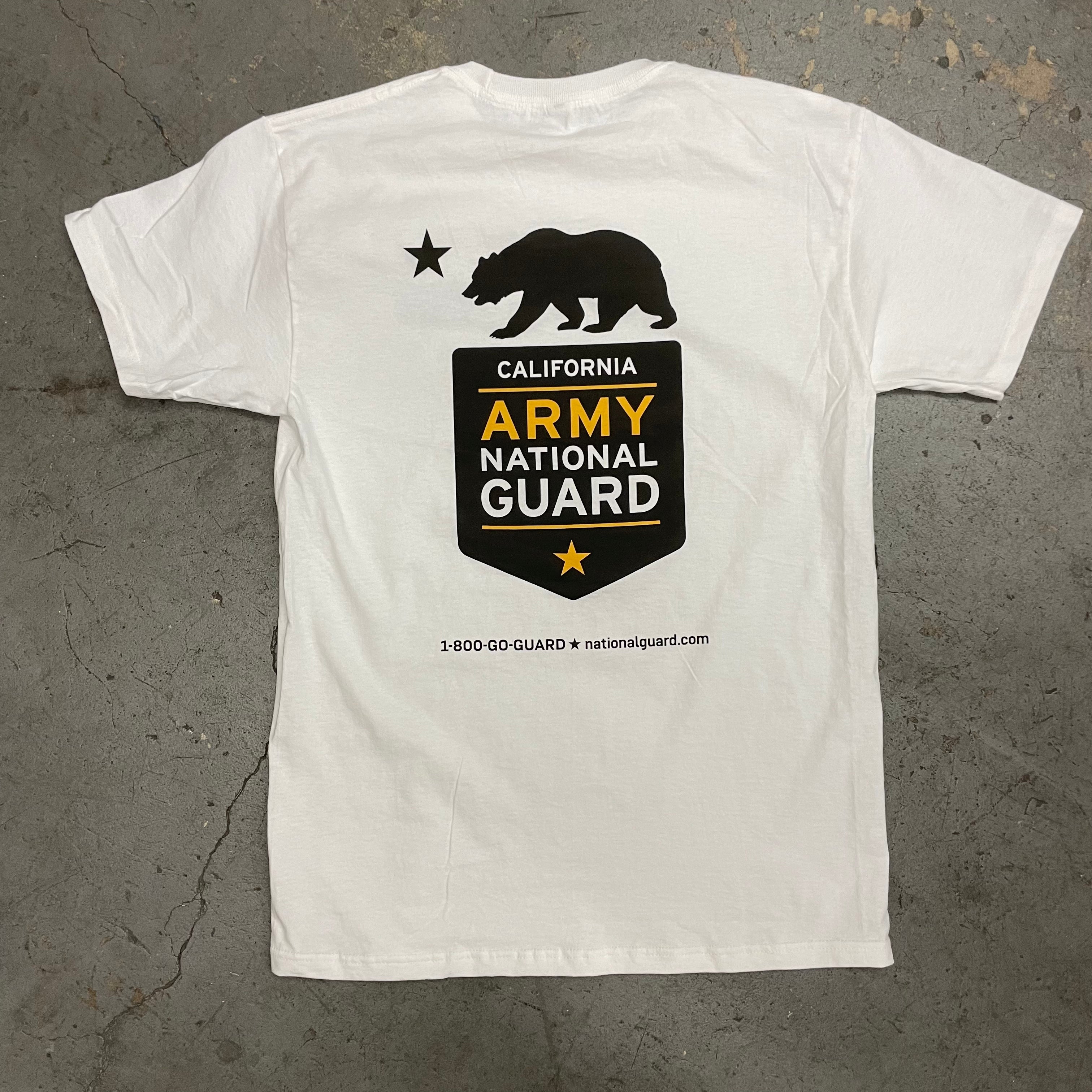 A white short-sleeve t-shirt laid flat on a gray concrete floor, featuring a black California Army National Guard graphic on the front with a bear, stars, and text.